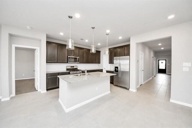 1307 Bonnerjee Dr, Crosby, TX 77532 - kitchen with stainless steel appliances, a sink, dark brown cabinets, a center island with sink, and baseboards