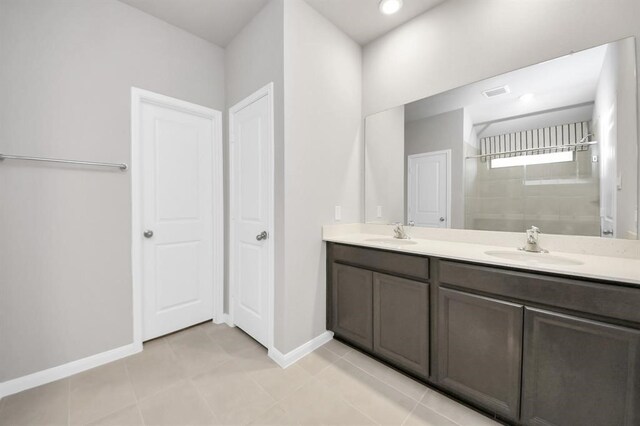 1307 Bonnerjee Dr, Crosby, TX 77532 - full bath with double vanity, baseboards, tiled shower, and tile patterned floors