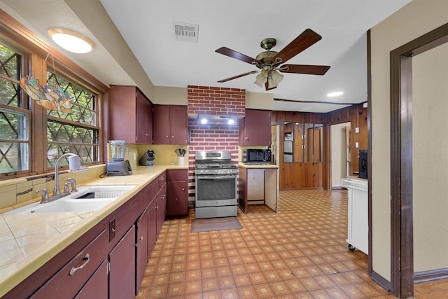 2009 Lamar Dr, Pasadena, TX 77502 - kitchen featuring stainless steel appliances, a sink, tile countertops, ceiling fan, and light flooring