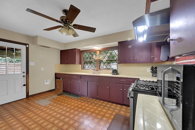 2009 Lamar Dr, Pasadena, TX 77502 - kitchen with tile countertops, a sink, ceiling fan, baseboards, and stainless steel range with gas cooktop