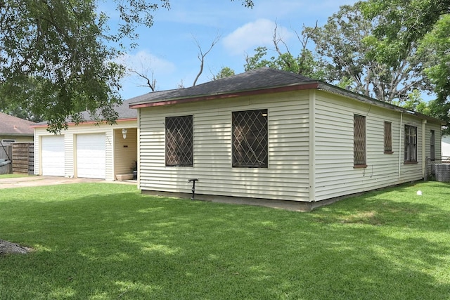 2009 Lamar Dr, Pasadena, TX 77502 - rear view of house with a lawn, concrete driveway, roof with shingles, and a garage