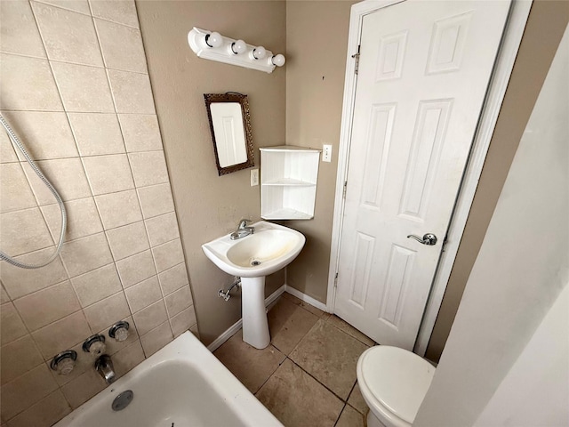 773 Lucky St, Houston, TX 77088 - bathroom with tile patterned floors, toilet,  shower combination, and baseboards