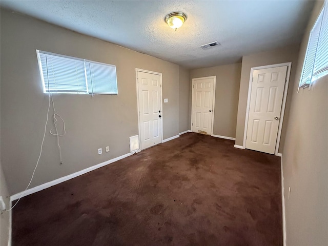 773 Lucky St, Houston, TX 77088 - entryway featuring baseboards, dark colored carpet, and a textured ceiling