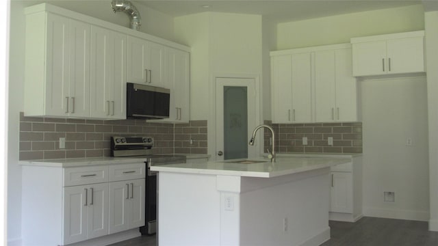336 Autumn Ln, Livingston, TX 77351 - kitchen featuring stainless steel appliances, white cabinetry, backsplash, a center island with sink, and light countertops