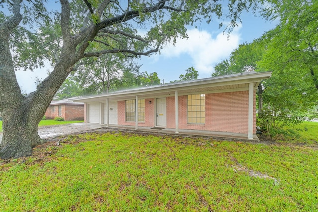 100 Harold Ln, Baytown, TX 77521 - ranch-style home with brick siding, concrete driveway, an attached garage, a front yard, and covered porch