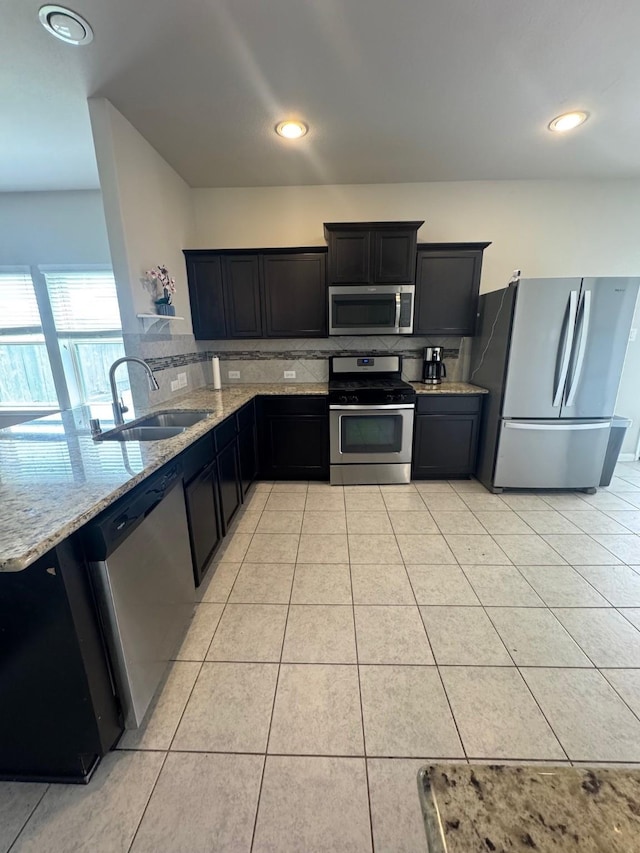 1938 Acaciawood Way, Houston, TX 77051 - kitchen featuring stainless steel appliances, a sink, light stone counters, backsplash, and light tile patterned floors