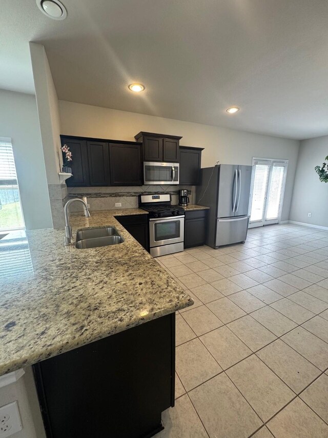 1938 Acaciawood Way, Houston, TX 77051 - kitchen with stainless steel appliances, a sink, light stone countertops, light tile patterned floors, and recessed lighting