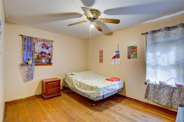2630 Tidewater Dr, Houston, TX 77045 - bedroom featuring light wood-style flooring, a ceiling fan, and baseboards