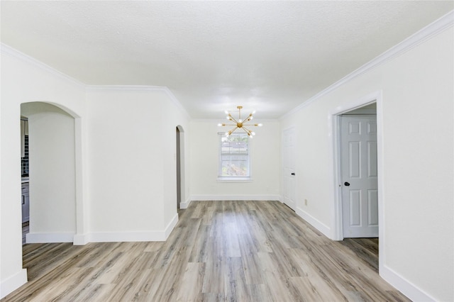 5326 Keystone St, Houston, TX 77021 - spare room with arched walkways, a chandelier, light wood-style floors, crown molding, and baseboards