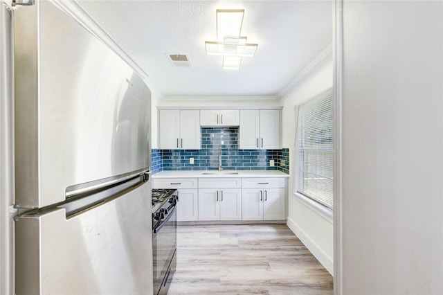 5326 Keystone St, Houston, TX 77021 - kitchen featuring freestanding refrigerator, ornamental molding, a sink, black range with gas cooktop, and light countertops