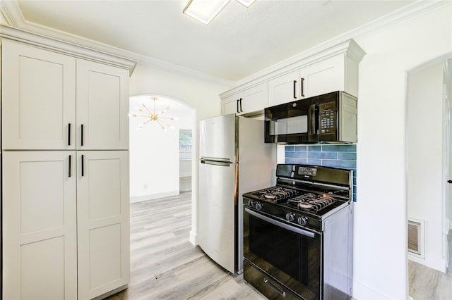 5326 Keystone St, Houston, TX 77021 - kitchen featuring black appliances, arched walkways, ornamental molding, light wood-style floors, and baseboards