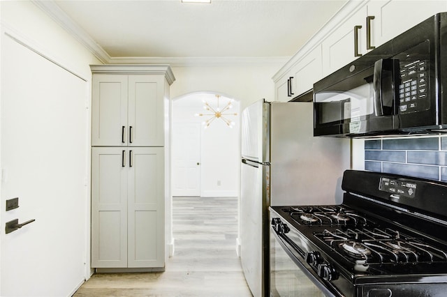 5326 Keystone St, Houston, TX 77021 - kitchen with black appliances, crown molding, decorative backsplash, light wood finished floors, and arched walkways
