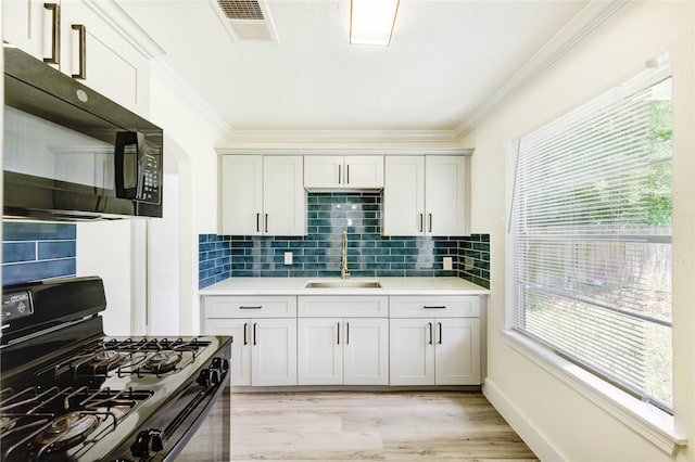 5326 Keystone St, Houston, TX 77021 - kitchen with black appliances, a sink, ornamental molding, light countertops, and decorative backsplash