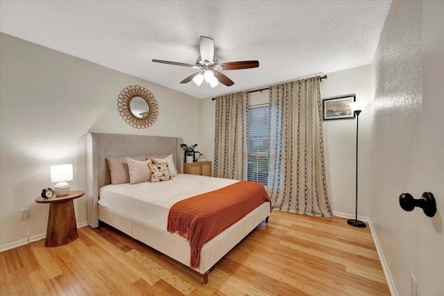 2120 El Paseo St Unit 2409, Houston, TX 77054 - bedroom featuring light wood-type flooring, baseboards, a ceiling fan, and a textured ceiling