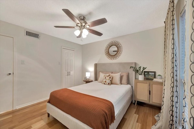2120 El Paseo St Unit 2409, Houston, TX 77054 - bedroom with light wood finished floors, ceiling fan, baseboards, and a textured ceiling