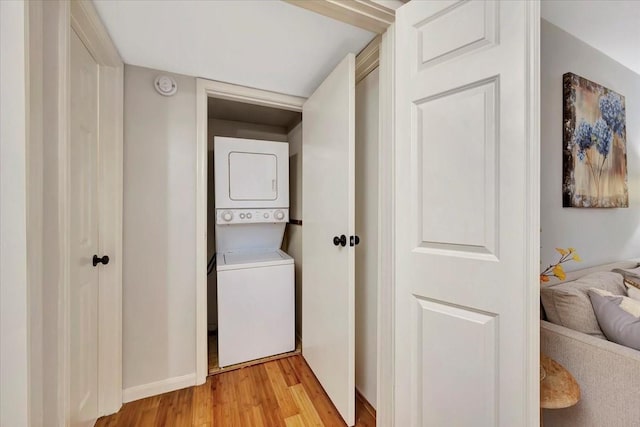 2120 El Paseo St Unit 2409, Houston, TX 77054 - laundry room featuring estacked washer and dryer, light wood-style floors, and baseboards
