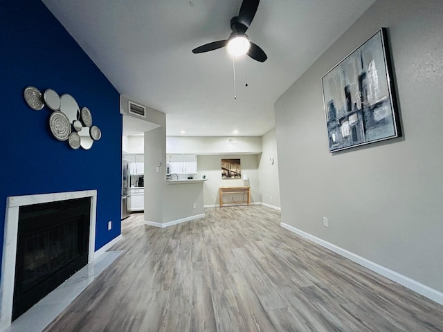 2121 El Paseo St Unit 1209, Houston, TX 77054 - living room featuring wood finished floors, a ceiling fan, a fireplace, and baseboards