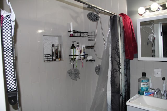 7615 Appleton St, Houston, TX 77022 - bathroom featuring a tile shower, tile walls, and vanity