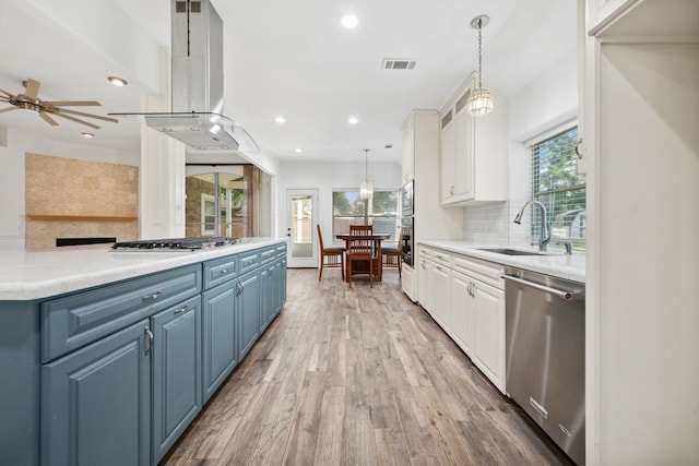 10323 Otter Cir, Baytown, TX 77523 - kitchen featuring appliances with stainless steel finishes, a sink, island exhaust hood, white cabinets, and recessed lighting