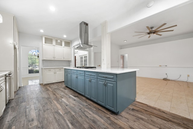 10323 Otter Cir, Baytown, TX 77523 - kitchen featuring island exhaust hood, blue cabinets, stainless steel gas cooktop, white cabinetry, and dark wood finished floors
