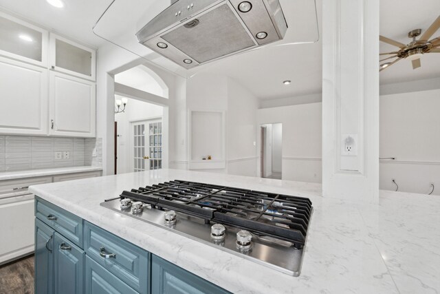 10323 Otter Cir, Baytown, TX 77523 - kitchen featuring stainless steel gas cooktop, extractor fan, blue cabinets, white cabinetry, and decorative backsplash