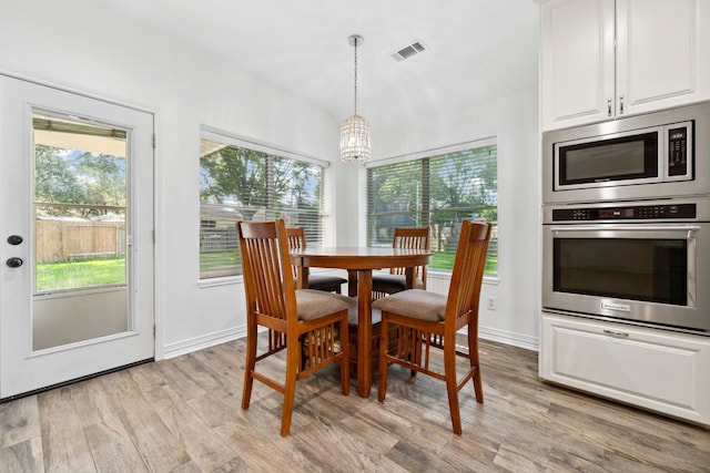 10323 Otter Cir, Baytown, TX 77523 - dining room featuring a chandelier, light wood-style floors, healthy amount of natural light, and baseboards