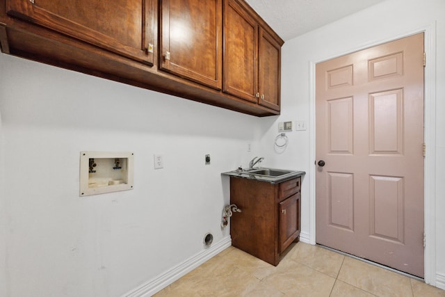 10323 Otter Cir, Baytown, TX 77523 - laundry area featuring washer hookup, electric dryer hookup, cabinet space, light tile patterned floors, and baseboards