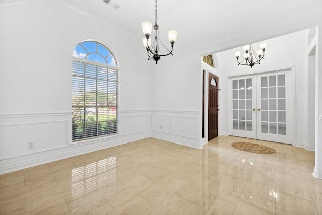 10323 Otter Cir, Baytown, TX 77523 - unfurnished room with a chandelier, vaulted ceiling, french doors, a wainscoted wall, and a decorative wall