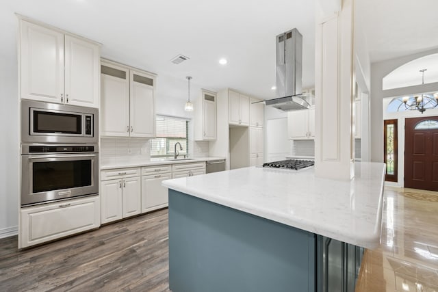 10323 Otter Cir, Baytown, TX 77523 - kitchen with stainless steel appliances, island exhaust hood, a sink, tasteful backsplash, and a peninsula
