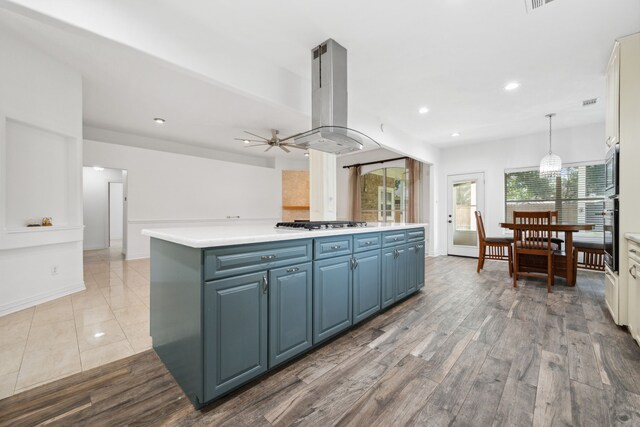 10323 Otter Cir, Baytown, TX 77523 - kitchen with island exhaust hood, blue cabinetry, a kitchen island, light countertops, and ceiling fan