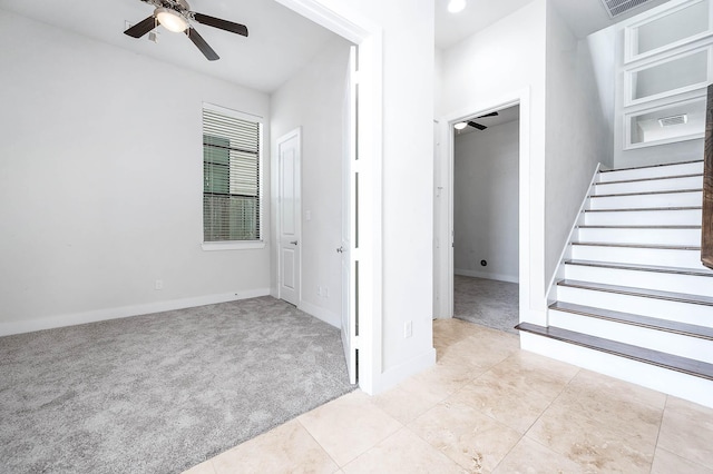 24 N N Hutcheson St, Houston, TX 77003 - empty room with light colored carpet, a ceiling fan, stairway, light tile patterned flooring, and baseboards
