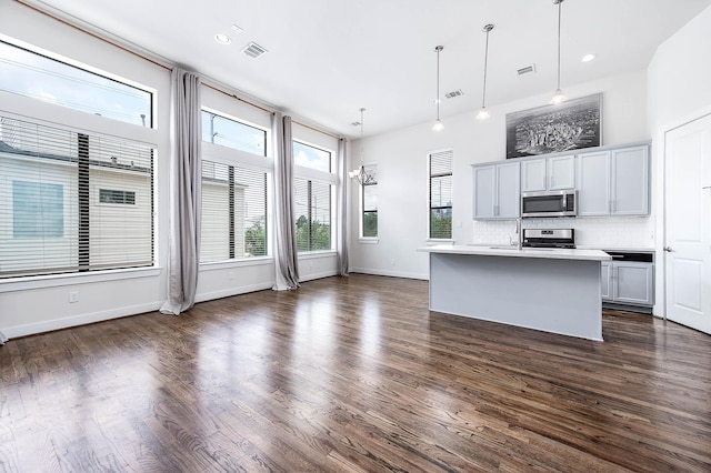24 N N Hutcheson St, Houston, TX 77003 - kitchen featuring stainless steel microwave, stove, light countertops, decorative backsplash, and dark wood-type flooring
