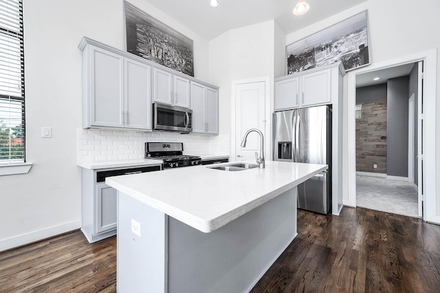 24 N N Hutcheson St, Houston, TX 77003 - kitchen featuring appliances with stainless steel finishes, a sink, dark wood-type flooring, a center island with sink, and light countertops
