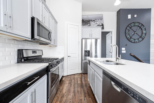 24 N N Hutcheson St, Houston, TX 77003 - kitchen featuring appliances with stainless steel finishes, a sink, backsplash, dark wood-type flooring, and white cabinets