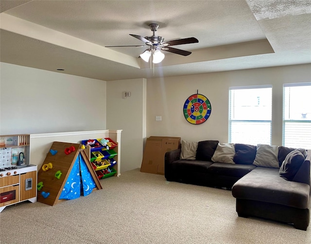 19042 Yaupon Ranch Dr, Cypress, TX 77433 - living area with carpet, a tray ceiling, a ceiling fan, and a textured ceiling