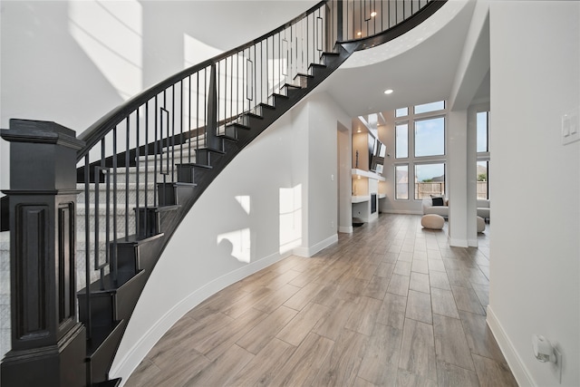 18011 Brazos River Cir, Cypress, TX 77433 - staircase with a towering ceiling, baseboards, wood finished floors, and recessed lighting