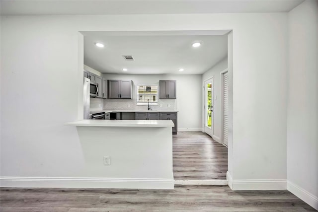 5751 Belmark St, Houston, TX 77033 - kitchen featuring gray cabinets, recessed lighting, stainless steel appliances, baseboards, and backsplash