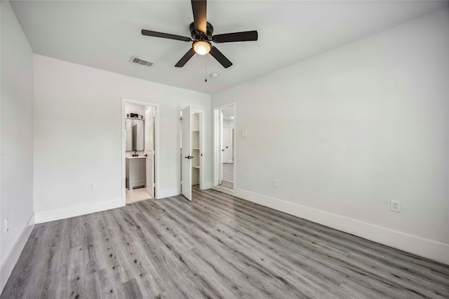 5751 Belmark St, Houston, TX 77033 - unfurnished bedroom with wood finished floors, baseboards, ensuite bathroom, and ceiling fan