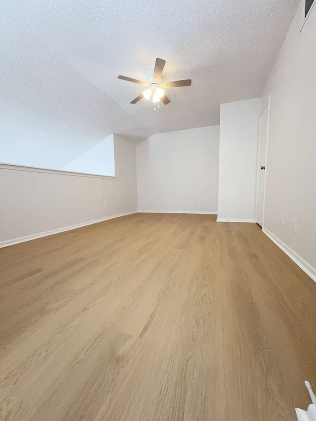 10855 Meadowglen Ln Unit 1121, Houston, TX 77042 - empty room featuring light wood-style floors, a ceiling fan, a textured ceiling, and baseboards