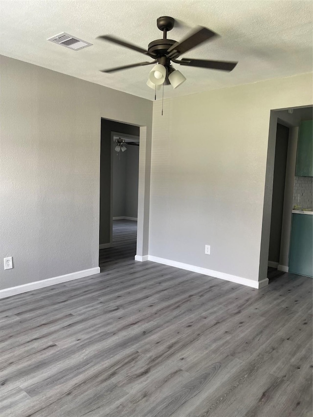 8630 Flossie Mae St, Houston, TX 77029 - empty room with ceiling fan, wood finished floors, baseboards, and a textured ceiling