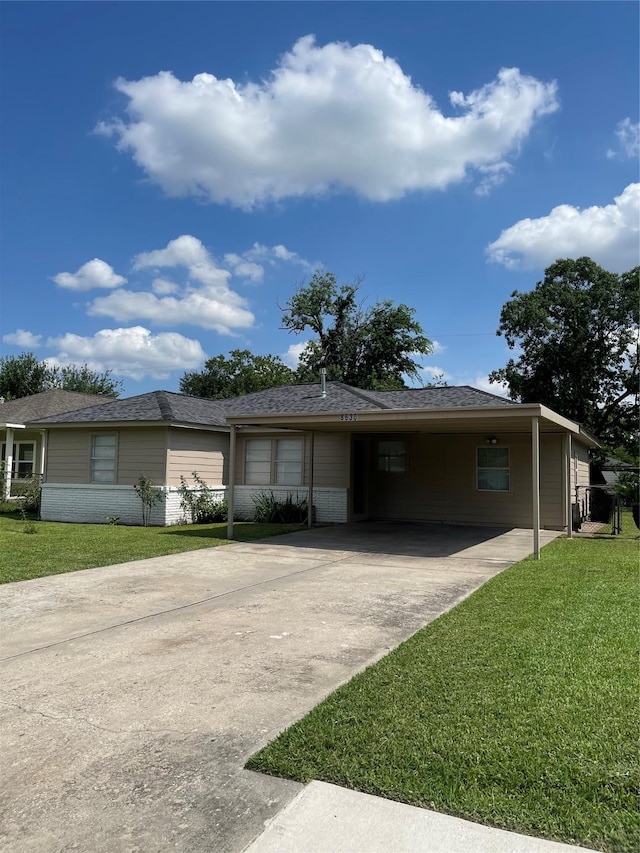 8630 Flossie Mae St, Houston, TX 77029 - ranch-style house with concrete driveway, a front yard, brick siding, and an attached carport
