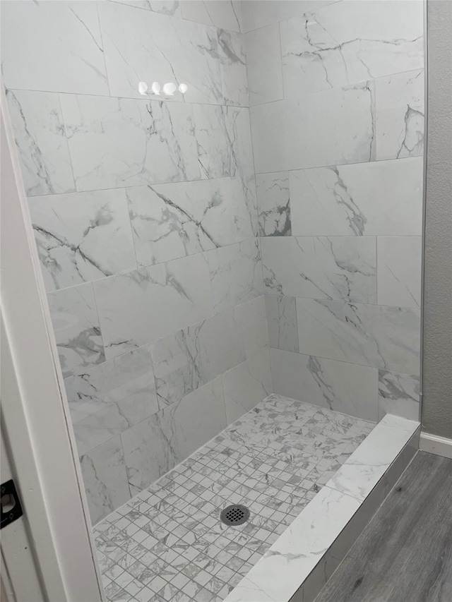 8630 Flossie Mae St, Houston, TX 77029 - bathroom featuring tiled shower and wood finished floors
