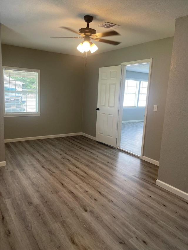 8630 Flossie Mae St, Houston, TX 77029 - unfurnished room featuring wood finished floors, ceiling fan, baseboards, and a textured ceiling
