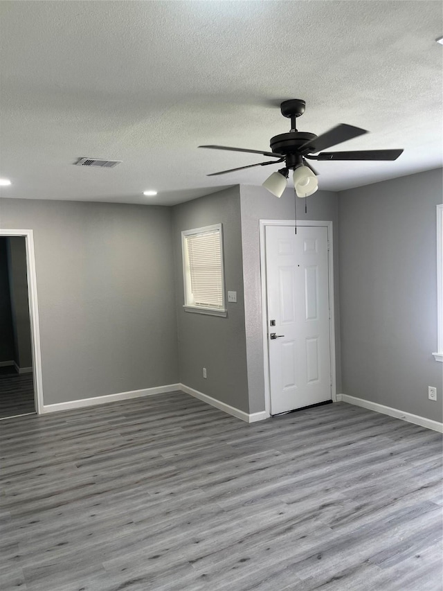 8630 Flossie Mae St, Houston, TX 77029 - entryway featuring ceiling fan, a textured ceiling, baseboards, and wood finished floors