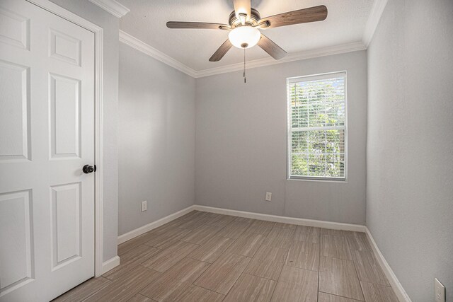 7449 Walker St, Houston, TX 77011 - spare room with light wood finished floors, ceiling fan, baseboards, and crown molding
