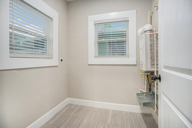 7449 Walker St, Houston, TX 77011 - interior space with baseboards, electric dryer hookup, tankless water heater, and plenty of natural light