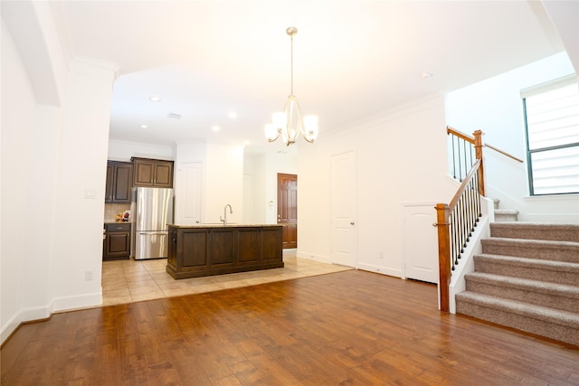 1306 Malone St, Houston, TX 77007 - unfurnished living room with a chandelier, stairs, light wood-type flooring, ornamental molding, and baseboards