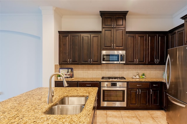 1306 Malone St, Houston, TX 77007 - kitchen with appliances with stainless steel finishes, a sink, ornamental molding, light stone countertops, and tasteful backsplash