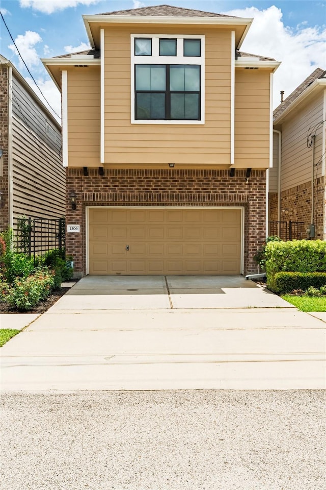 1306 Malone St, Houston, TX 77007 - view of front of property featuring a garage, brick siding, and concrete driveway