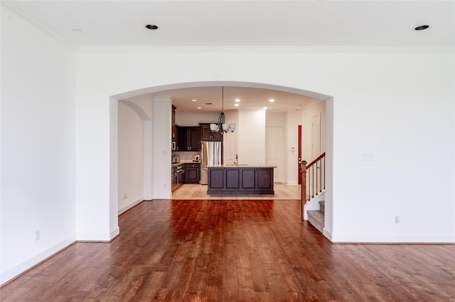 1306 Malone St, Houston, TX 77007 - unfurnished living room with wood finished floors, a chandelier, baseboards, stairs, and crown molding